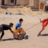 Trẻ em Palestine đi lấy nước sinh hoạt tại Khan Younis, Dải Gaza. (Ảnh: THX/TTXVN)
