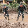 Cảnh sát cơ động hỗ trợ giúp dọn dẹp đường sá, giúp giao thông huyện Bảo Yên, tỉnh Lào Cai thông suốt, an toàn. (Ảnh: Hoàng Hiếu/TTXVN)