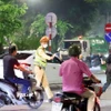 Cán bộ, chiến sỹ thuộc tổ công tác liên ngành Y6/141 dừng xe kiểm tra và xử lý 1 trường hợp vi phạm giao thông. (Ảnh: Phạm Kiên/TTXVN)