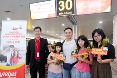 Những hành khách đầu tiên trên chuyến bay Vietjet kết nối Hà Nội-Thành Đô. (Ảnh: PV/Vietnam+)