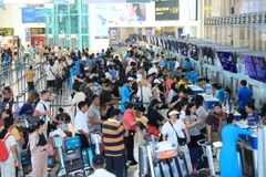 Hành khách làm thủ tục đi máy bay tại quầy vé của Vietnam Airlines. (Ảnh: Việt Hùng/Vietnam+)