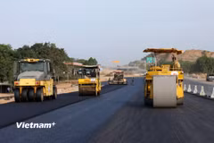 Nhà thầu huy động máy móc, nhân lực để thảm những mét bê tông nhựa cuối cùng để thi công tiếp hệ thống an toàn giao thông. (Ảnh: Khánh Hùng/Vietnam+)