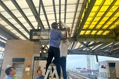 Nhân viên Hà Nội Metro che chắn bảng điện tử tại một sân ga của tuyến đường sắt đô thị Cát Linh-Hà Đông. (Ảnh: PV/Vietnam+)