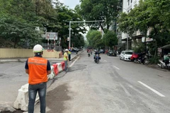 Công nhân nhà thầu thi công Dự án đường sắt đô thị đoạn Nhổn-Ga Hà Nội tổ chức phân luồng giao thông. (Ảnh: PV/Vietnam+)