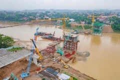Chủ đầu tư và nhà thầu thi công cầu Phong Châu mới thi công 3 ca, 4 kíp để đẩy tiến độ dự án. (Ảnh: Việt Hùng/Vietnam+)