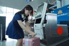 Hành khách tự gắn thẻ hành lý và thực hiện ký gửi tại quầy tự động ở Sân bay quốc tế Nội Bài. (Ảnh: PV/Vietnam+)