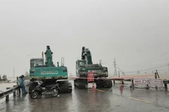 Lực lượng chức năng cấm đường và có các biển cảnh báo phương tiện không được lưu thông qua đoạn đường bị ngập, sạt lở. (Ảnh: PV/Vietnam+)