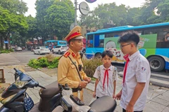 Lực lượng Cảnh sát giao thông Hà Nội xử lý và tuyên truyền kiến thức về an toàn giao thông cho học sinh chưa đủ tuổi điều khiển xe máy. (Ảnh: PV/Vietnam+)