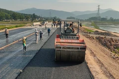 Nhà thầu thi công thảm nhựa nền đường một dự án đường bộ cao tốc. (Ảnh: Việt Hùng/Vietnam+)