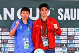 Huấn luyện viên Kim Sang-sik (áo xanh) và thủ môn Trung Kiên thể hiện quyết tâm tại họp báo trước trận bán kết gặp U23 Trung Quốc. (Ảnh: Ted Tran)