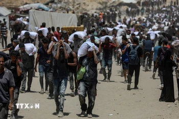 Người dân Palestine nhận hàng viện trợ nhân đạo tại Beit Lahia, phía Bắc Dải Gaza, ngày 1/8/2025. (Ảnh: THX/TTXVN)