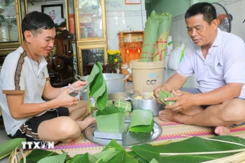 Để vơi bớt nỗi nhớ quê, anh Đại cùng bạn bè quê Hà Tĩnh đang sinh sống, lập nghiệp tại khu vực phường Mỹ Thới (tỉnh An Giang) tổ chức gói bánh chưng để tìm lại vị Tết quê. (Ảnh: Công Mạo/TTXVN)
