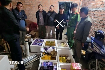 Cơ quan chức năng khám xét nơi cất giữ pháo nổ cảu đối tượng Phong. (Ảnh: TTXVN phát)