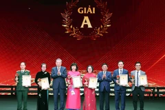 Tổng Bí thư Tô Lâm và ông Trần Cẩm Tú, Ủy viên Bộ Chính trị, Thường trực Ban Bí thư, Chủ nhiệm Ủy ban Kiểm tra Trung ương trao giải A Giải Báo chí toàn quốc về xây dựng Đảng (Giải Búa liềm Vàng) lần thứ 9-năm 2024 cho các tác giả, nhóm tác giả. (Ảnh: Thống Nhất/TTXVN)