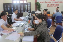 Hướng dẫn người dân cập nhật thông tin về đất đai tại Trung tâm Phục vụ Hành chính công xã Kim Thành. (Ảnh: Minh Thu/TTXVN)