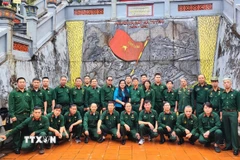 Hội Cựu chiến binh TTXVN chụp ảnh lưu niệm tại Đài tưởng niệm các Anh hùng Liệt sỹ điểm cao 468 (thôn Nặm Ngặt, xã Thanh Thủy, tỉnh Tuyên Quang). (Ảnh: Minh Tâm/TTXVN)