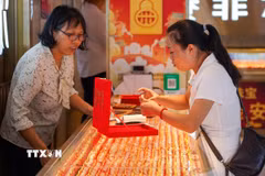 Khách hàng chọn mua trang sức vàng tại một cửa hàng ở tỉnh Quý Châu, Trung Quốc. (Ảnh: THX/TTXVN)