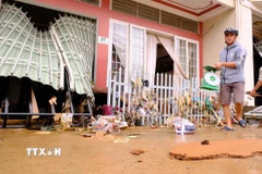 Người dân trên đường Trần Hưng Đạo (trung tâm xã D’ran, Lâm Đồng) quay trở về thu dọn đồ đạc trong sáng 20/11, sau khi nước lũ đã rút bớt. (Ảnh: Nguyễn Dũng/TTXVN)