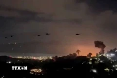 Trực thăng bay qua khu vực khói bốc lên từ loạt vụ nổ ở thủ đô Caracas, Venezuela, ngày 3/1/2026. (Nguồn: Reuters/TTXVN)