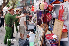 Tổ công tác của Công an phường Hoàn Kiếm xử lý vi phạm về trật tự đô thị tại phố Trần Phú. (Ảnh: Phạm Kiên/TTXVN)