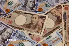 Đồng tiền mệnh giá 10.000 yen và 100 USD. (Ảnh: AFP/TTXVN)