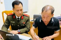 Các đối tượng tự giác gỡ bỏ bài viết, cam kết chấp hành quyết định xử phạt vi phạm hành chính. (Ảnh: TTXVN phát)