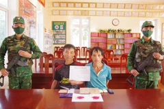 Hai đối tượng cùng tang vật vụ án. (Ảnh: TTXVN phát)