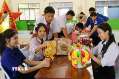 Các em học sinh Việt Nam-Lào háo hức chuẩn bị Tết Trung thu. (Ảnh: Xuân Tú/TTXVN)