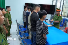Cơ quan Cảnh sát điều tra Công an tỉnh Đồng Tháp tống đạt Quyết định khởi tố và ra Lệnh cấm đi khỏi nơi cưu trú đối với 5 bị can. (Ảnh: TTXVN phát)