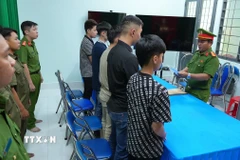 Cơ quan Cảnh sát điều tra Công an tỉnh Đồng Tháp tống đạt Quyết định khởi tố và ra Lệnh cấm đi khỏi nơi cưu trú đối với 5 bị can. (Ảnh: TTXVN phát)