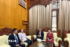 Đại sứ Việt Nam tại Lào Nguyễn Minh Tâm tới thăm và chúc Tết cộng đồng người Việt tại thủ đô Vientiane. (Ảnh: TTXVN phát)