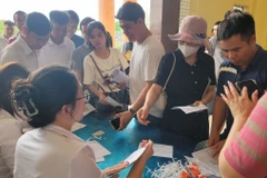Người dân làm thủ tục trước khi bước vào phiên đấu giá đất tại xã Đình Dù, Văn Lâm (Hưng Yên). (Ảnh: Mạnh Khánh/TTXVN)