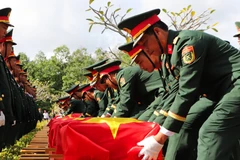 Đội tiêu binh thực hiện nghi thức an táng liệt sỹ. (Ảnh: Hồng Thái/TTXVN)