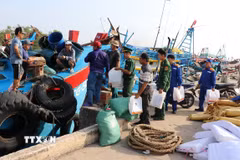 Bộ đội Biên phòng tỉnh Đồng Tháp tặng quà và tuyên truyền về phòng, chống khai thác IUU cho ngư dân ở Cảng cá Vàm Láng, xã Gia Thuận, tỉnh Đồng Tháp. (Ảnh: Hữu Chí/TTXVN)