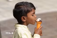 Em nhỏ ăn kem giải nhiệt trong ngày nắng nóng tại Amritsar, bang Punjab, Ấn Độ. (Nguồn: THX/TTXVN)