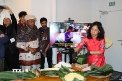 Chị Nguyễn Thị Liên, Việt kiều tại Brussels, giới thiệu cách gói bánh chưng. (Ảnh: Hương Giang/TTXVN)