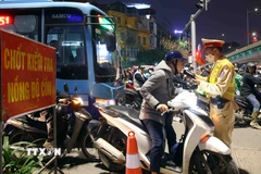 Cán bộ, chiến sỹ cảnh sát giao thông kiểm tra đồng nồng độ cồn với người tham gia giao thông. (Ảnh: Phạm Kiên/TTXVN)