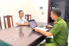 Cơ quan chức năng lấy lời khai 1 trong 6 đối tượng bị bắt về hành vi "Mua bán người” và “Mua bán trẻ em." (Ảnh: TTXVN phát)