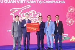 Đại sứ Việt Nam tại Campuchia Nguyễn Minh Vũ (thứ hai, từ trái sang) trao tặng tượng trưng 300 suất quà Tết tổng trị giá 15.000 USD cho Lãnh đạo Hội Khmer-Việt Nam tại Campuchia hỗ trợ bà con nghèo tại 24 tỉnh, thành ở Campuchia. (Ảnh: Hoàng Minh/TTXVN)