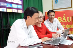 Bí thư chi bộ Thôn 3 Lộc Ngãi Hồ Thị Hồng Liên (ngồi giữa) cùng các cán bộ thôn giám sát hoạt động của thôn thông qua 12 camera lắp trên toàn thôn. (Ảnh: Chu Quốc Hùng/TTXVN)