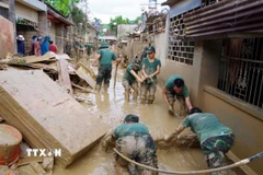 Lực lượng Sư đoàn 324 hỗ trợ người dân xã Tương Dương khắc phục hậu quả mưa lũ. (Ảnh: TTXVN phát)