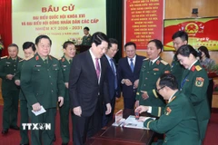 Chủ tịch nước Lương Cường nhận thẻ cử tri đã đóng dấu xác nhận bỏ phiếu tại khu vực bỏ phiếu số 26, phường Hoàn Kiếm, thành phố Hà Nội. (Ảnh: Lâm Khánh/TTXVN)