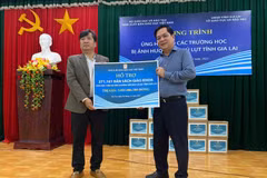 Ông Lê Huy, Phó Tổng Giám đốc Nhà Xuất bản Giáo dục Việt Nam, (phải) trao biển tặng sách giáo khoa cho ông Trần Bá Công, Phó Giám đốc Sở Giáo dục và Đào tạo tỉnh Gia Lai. (Nguồn: PV/Vietnam+)