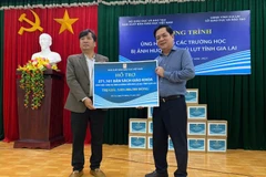 Ông Lê Huy, Phó Tổng Giám đốc Nhà Xuất bản Giáo dục Việt Nam, (phải) trao biển tặng sách giáo khoa cho ông Trần Bá Công, Phó Giám đốc Sở Giáo dục và Đào tạo tỉnh Gia Lai. (Nguồn: PV/Vietnam+)