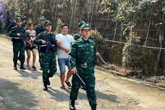 Bội đội biên phòng áp giải 2 đối tượng mua bán người trong chuyên án. (Ảnh: TTXVN phát)