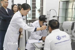 Các bác sỹ Đoàn Y tế tỉnh Vân Nam, Trung Quốc thăm khám cho bệnh nhân trước khi phẫu thuật. (Ảnh: Xuân Tư/TTXVN)