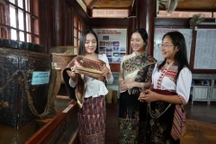 Em Bounsana Thidasavanh và các bạn tìm hiểu văn hóa truyền thống của Việt-Lào. (Ảnh: Bích Huệ/TTXVN)