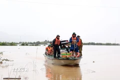 Người dân xã Suối Hiệp, tỉnh Khánh Hòa được lực lượng cứu hộ sử dụng phương tiện chuyên dụng đưa đến nơi an toàn. (Ảnh: Xuân Triệu/TTXVN)