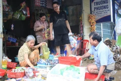 Người dân phường Tây Nha Trang, tỉnh Khánh Hòa lau dọn những nhu yếu phẩm còn sử dụng được sau ngập lụt. (Ảnh: Phan Sáu/TTXVN)