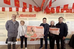 Phó Tổng biên tập Quế Đình Nguyên (giữa) trao Phụ san đặc biệt của báo Nhân Dân chào mừng 80 năm Quốc khánh Việt Nam. (Ảnh: Hữu Chiến/TTXVN)